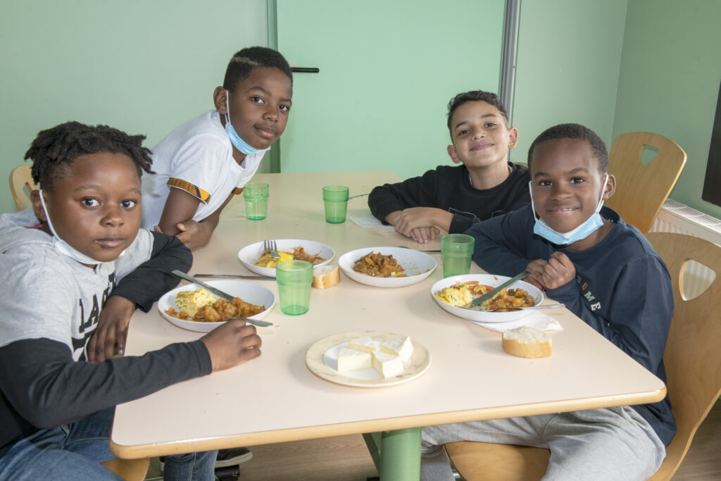 Quatre jeunes garçons déjeunant